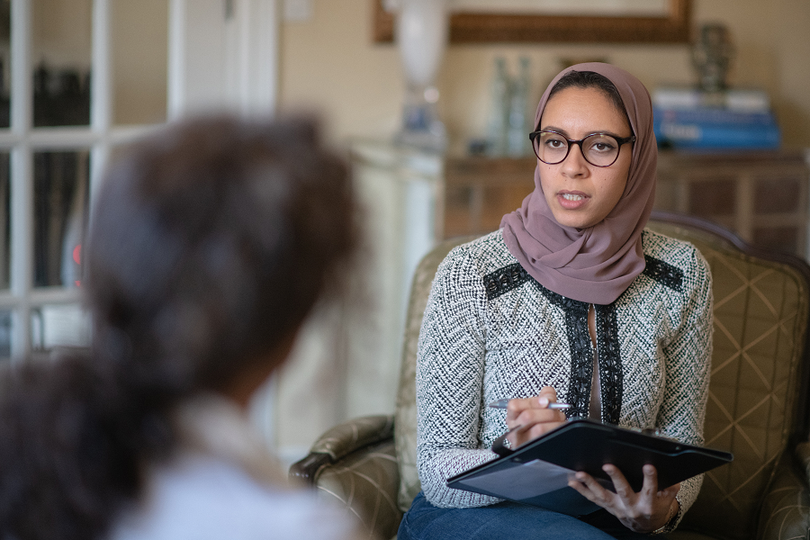 a therapist and client sitting in chairs during a session, having a conversation