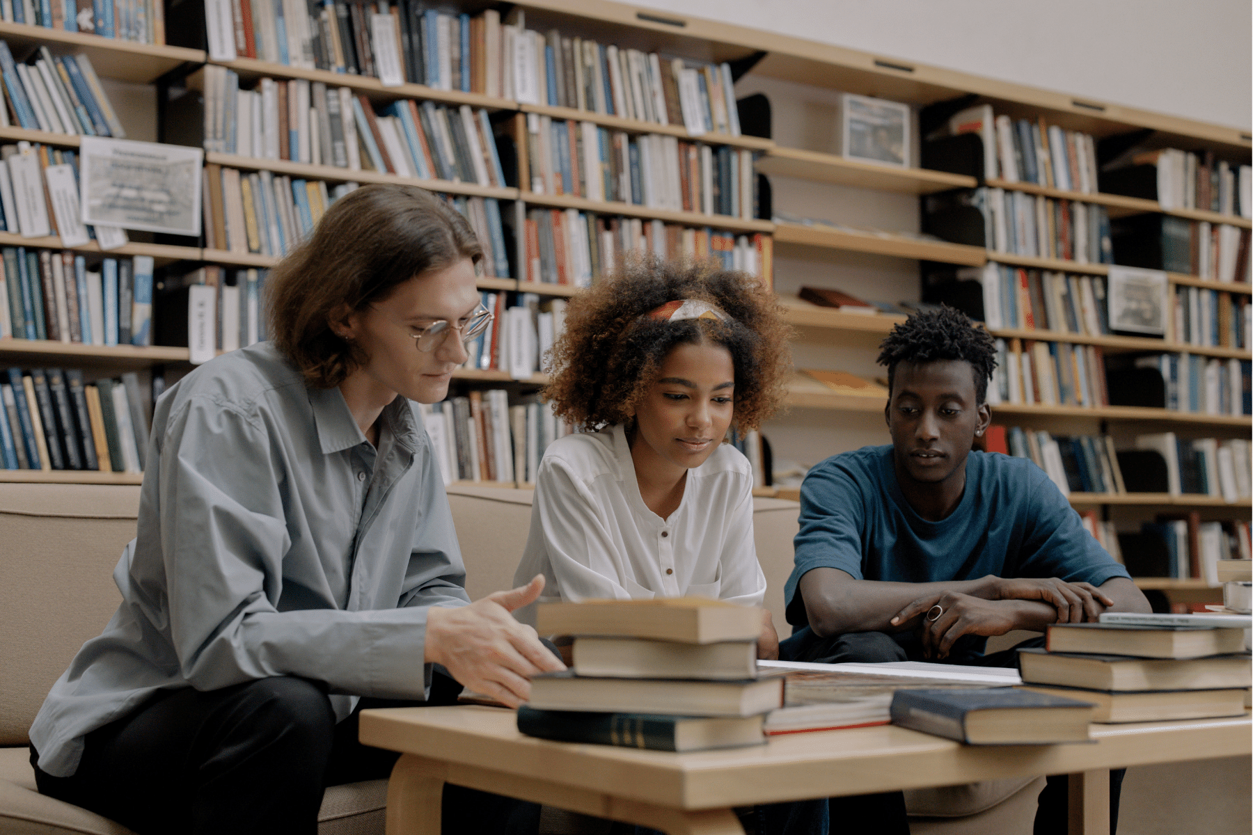 picture of a library with people sitting with their heads down reading books